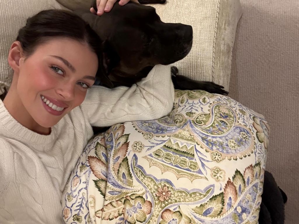 Nicola peltz selfie on sofa with black dog