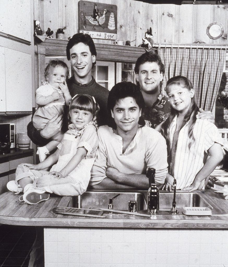 Promotional portrait of the cast of the television series, 'Full House,' L-R: Ashley or Mary Kate Olsen, Bob Saget, David Coulier, Candace Cameron, John Stamos, and Jodie Sweetin, circa 1987