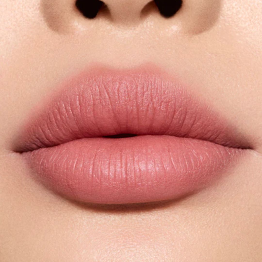 A CLOSE UP IMAGE of a womans lips wearing pink rosy lipstck