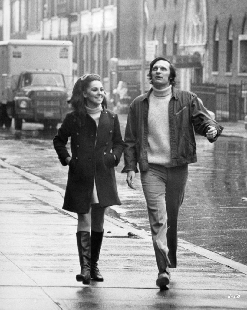 Marlo Thomas and Alan Alda enjoy a walk in the rain in a scene from the film 'Jenny', 1970.