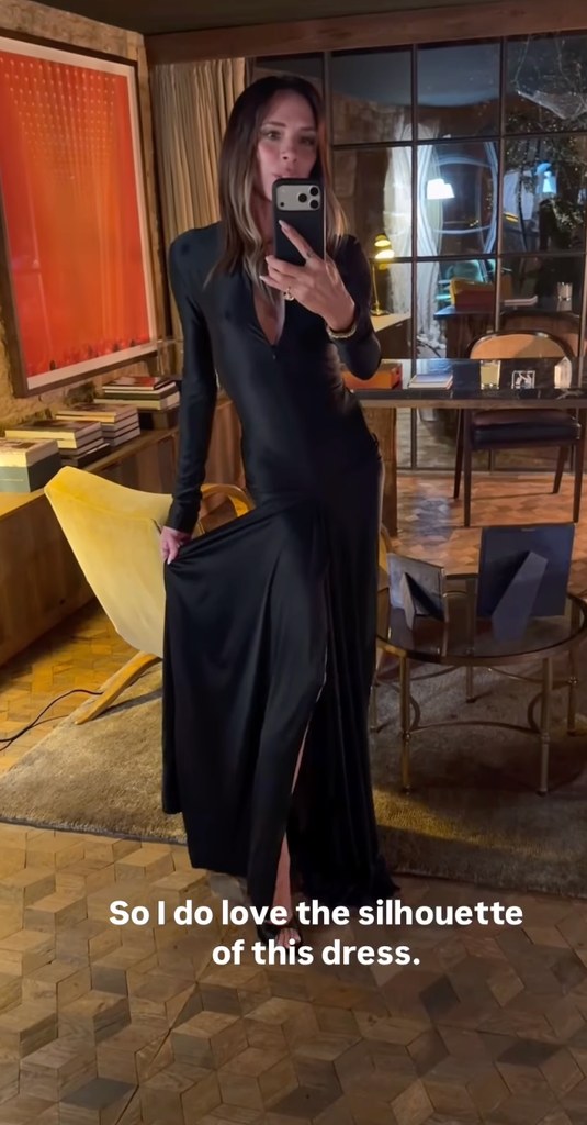 Victoria Beckham wears a long black slinky dress in a living room