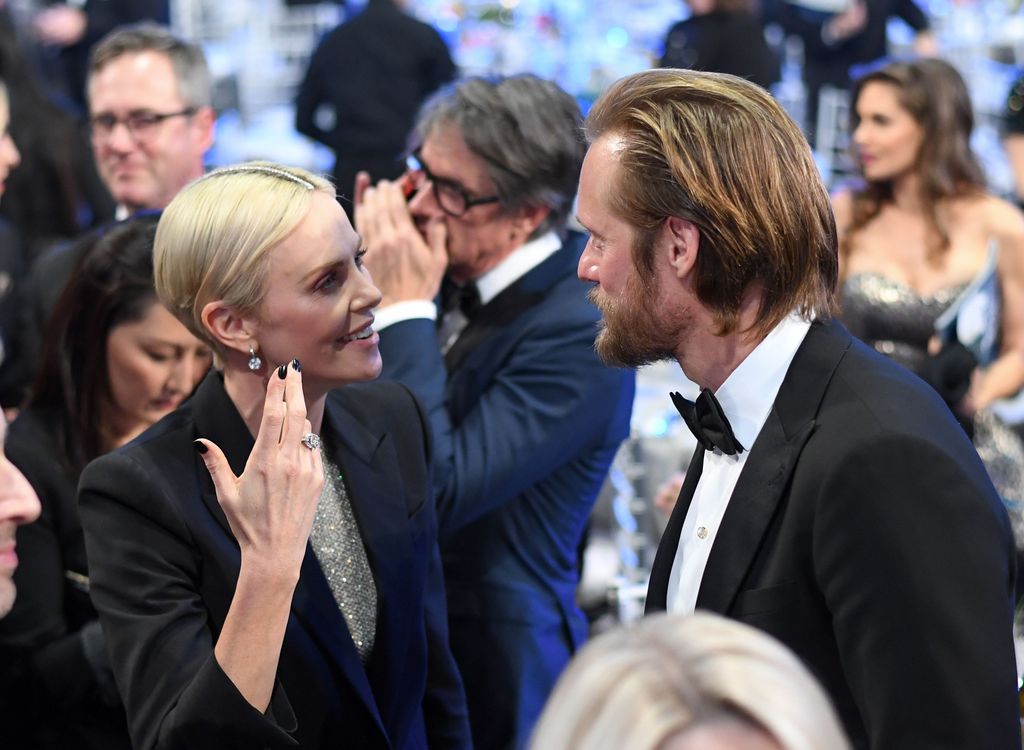 Charlize Theron in black blazer and Alexander Skarsgard in tuxedo speak during the 26th Annual Screen Actors Guild Awards show 