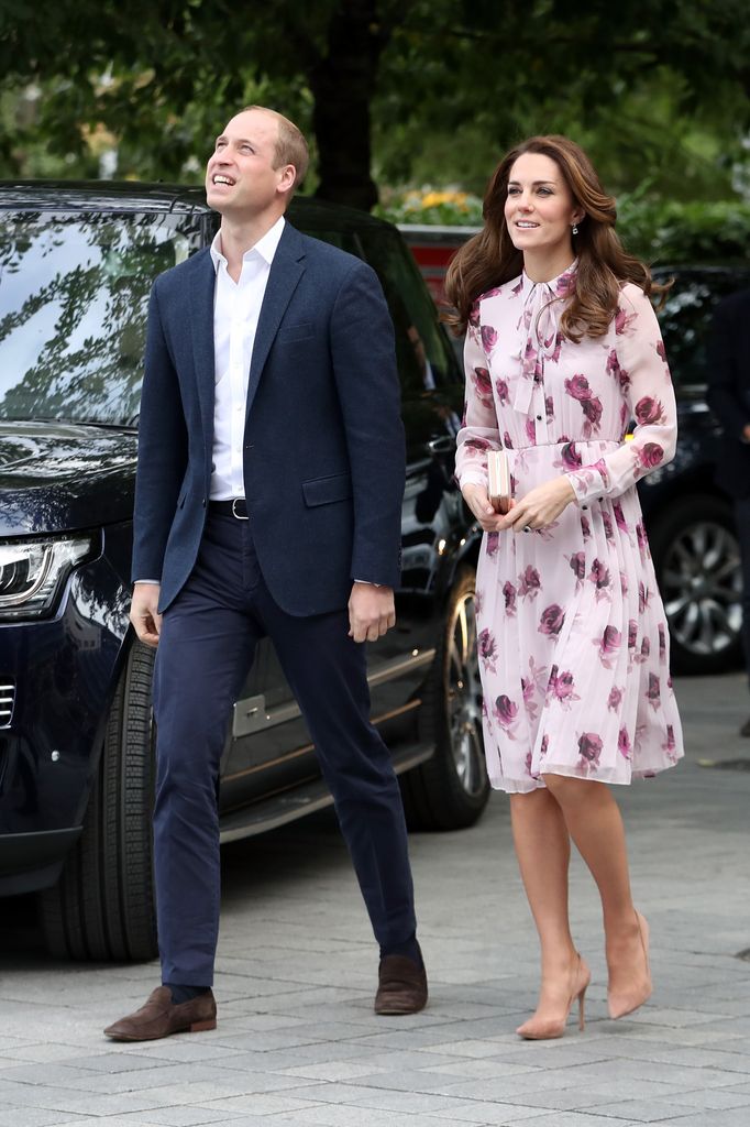 Prince William looking up beside kate in pink floral dress