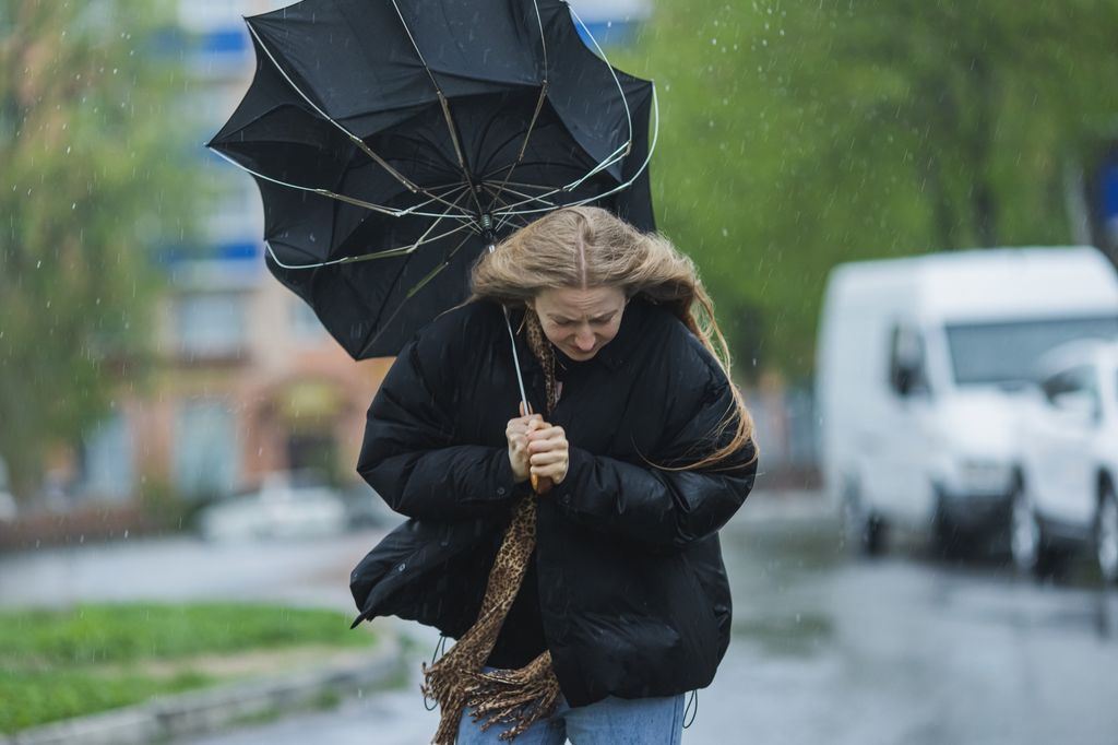 A woman walking with an umbrella turned inside out
