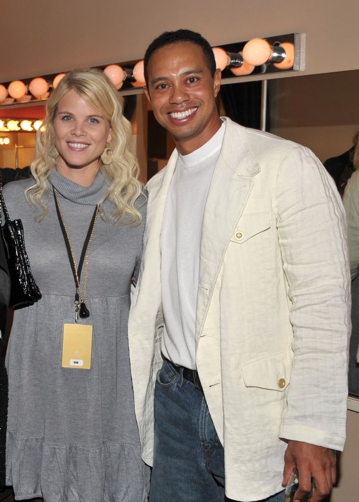 Tiger Woods and Elin Woods smiling for a photo at a party