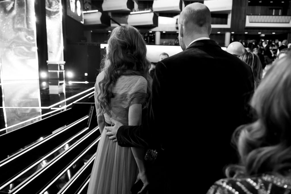 He placed his hand protectively on her back at one point during the evening