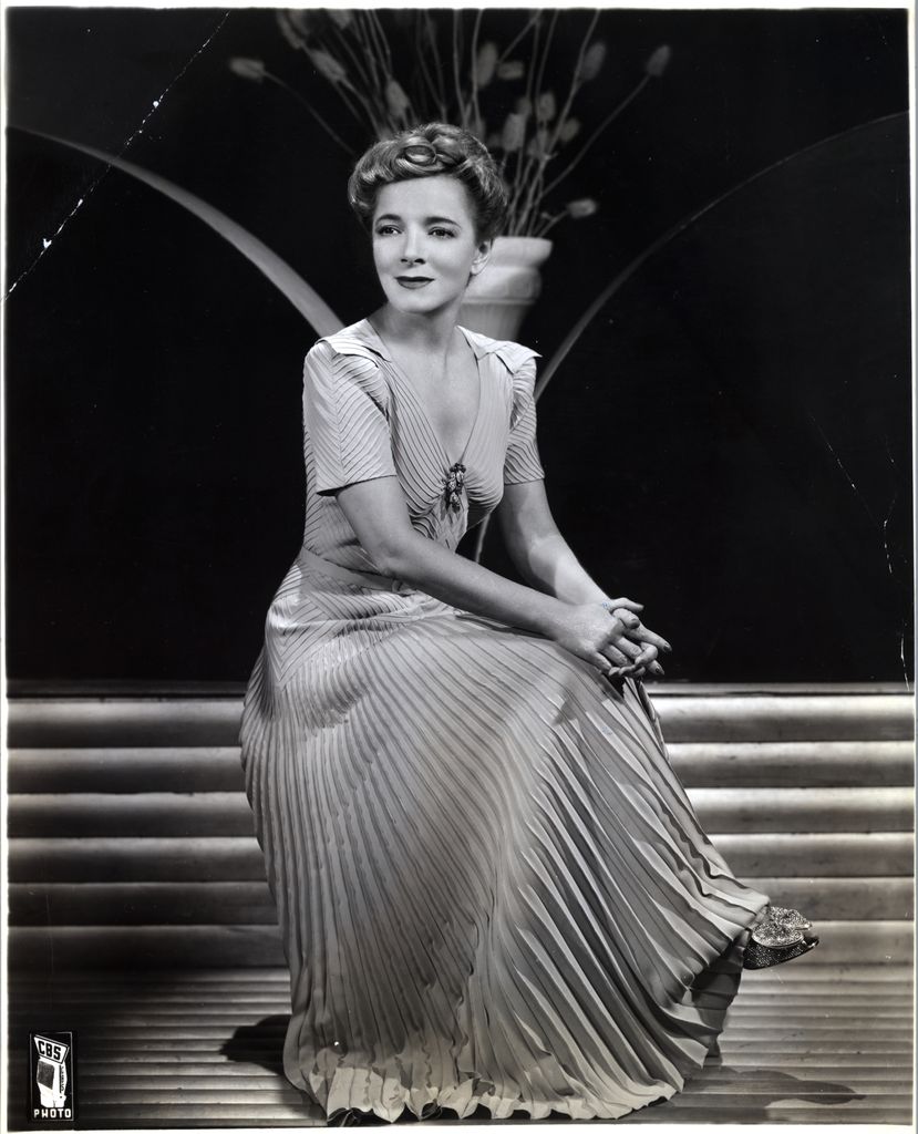 Helen Hayes is shown seated on a stool