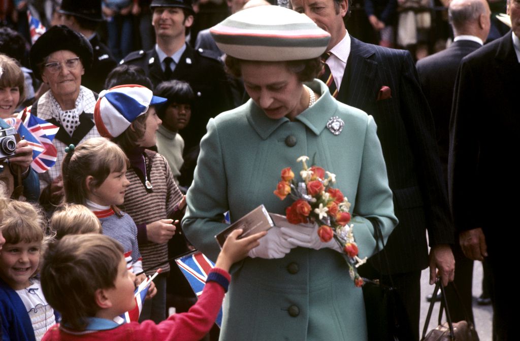 small boy handing queen a chocolate bar