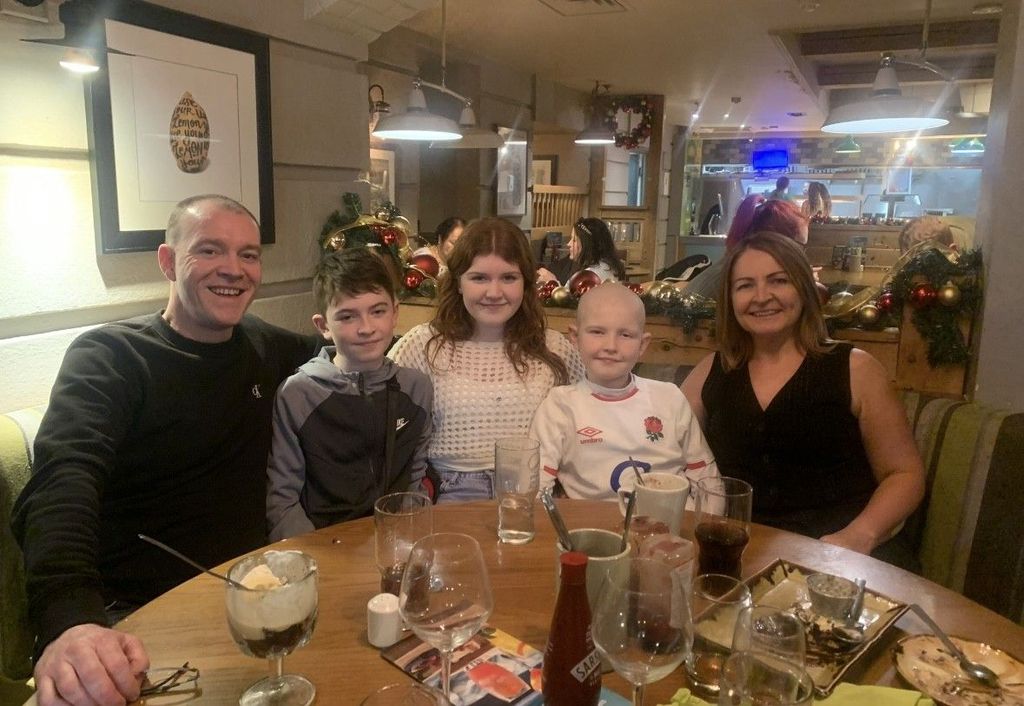 mum, dad and three kids at table in restaurant
