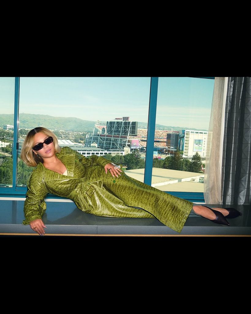 A photo of Beyonce lying down wearing a green coat