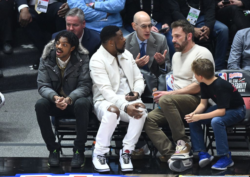 NBA Commissioner Adam Silver (C) speaks with actors Ben Affleck and his son Samuel Garner Affleck (R) with Chris Tucker and his son Destin Christopher Tucker (L) as they attend the 2023 Ruffles All-Star Celebrity Game during NBA All-Star Weekend 
