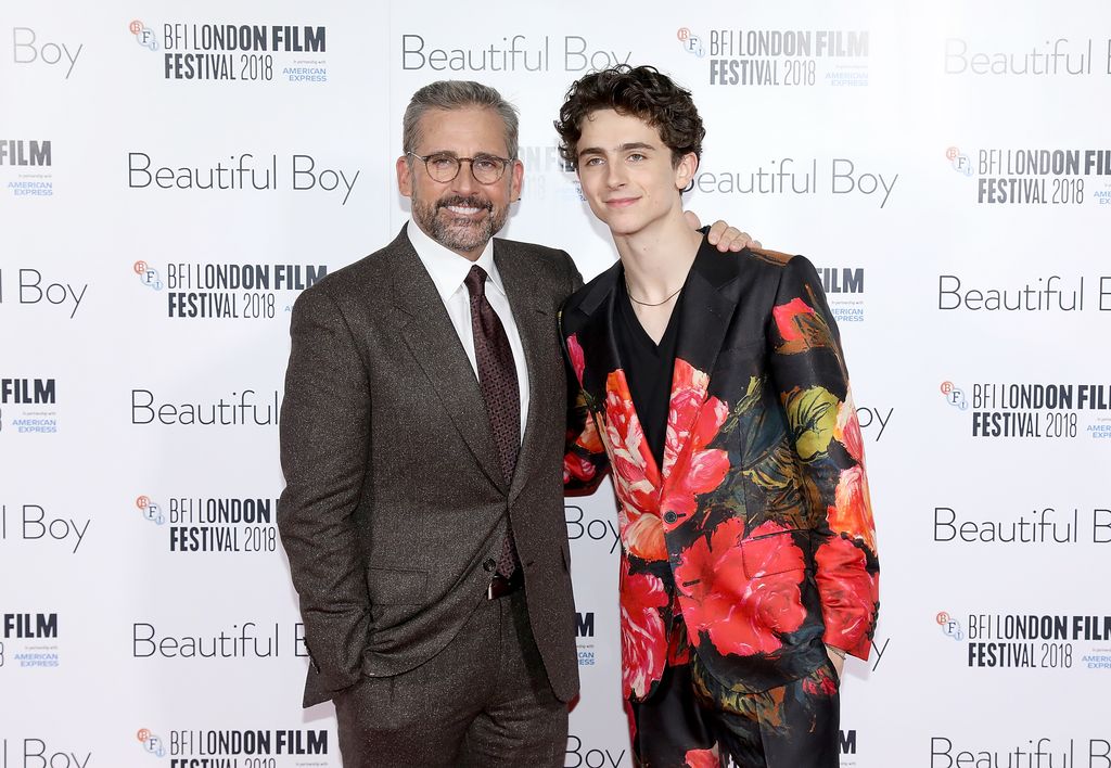 Steve Carell and Timothee Chalamet smiling with their arms around eachother 