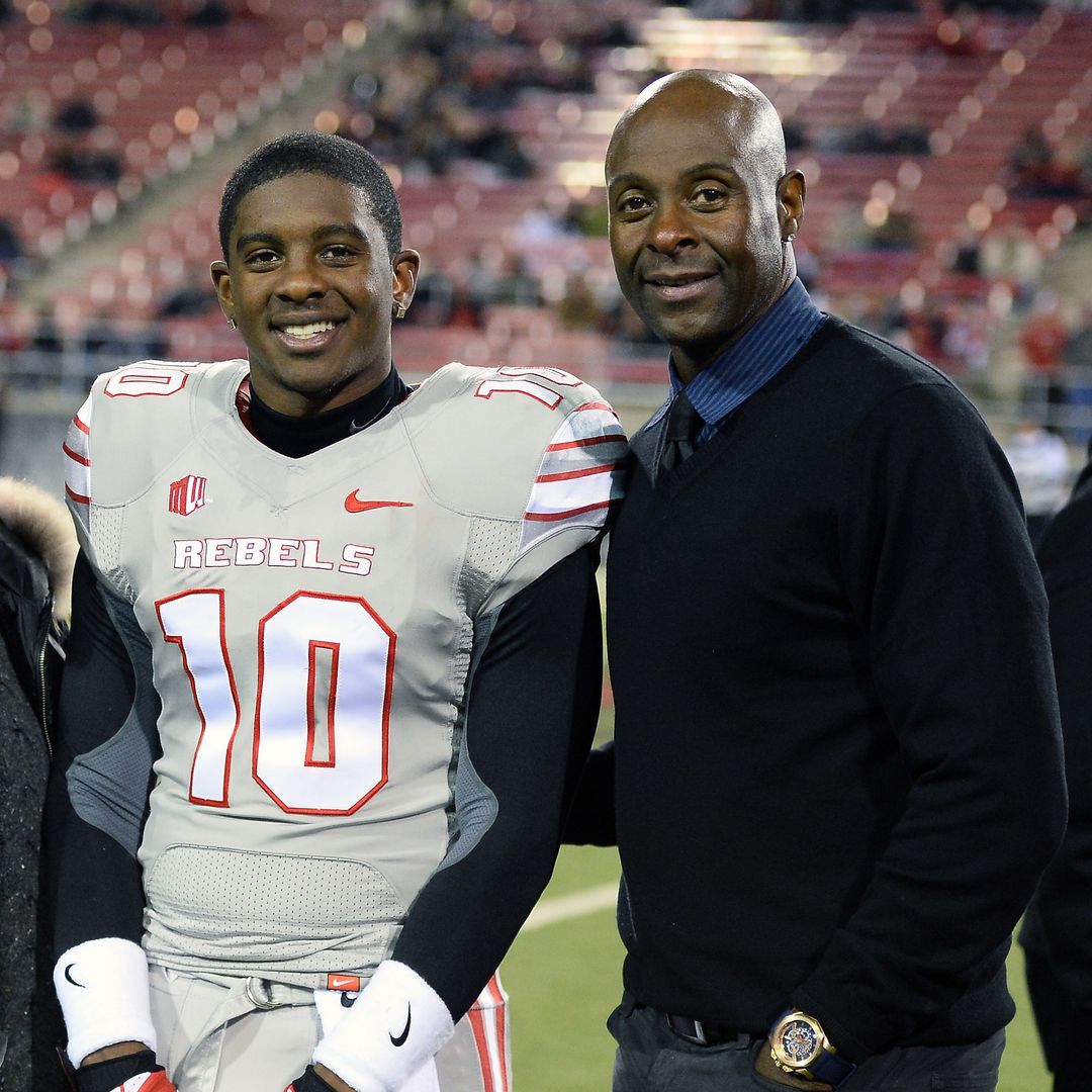 Jerry Rice Jr. #10 of the UNLV Rebels poses with his father, Hall of Fame National Football League player Jerry Rice, during senior night festivities on the field before UNLV's game against the San Diego State Aztecs at Sam Boyd Stadium on November 30, 2013 in Las Vegas, Nevada.