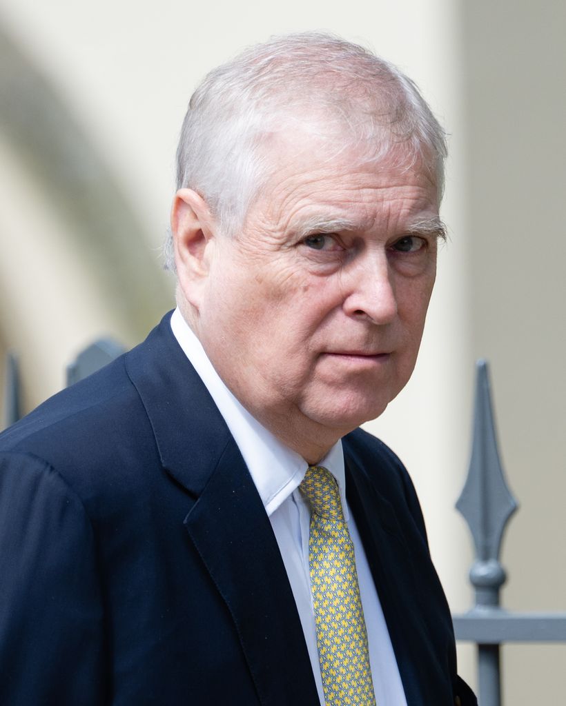 Andrew Mountbatten Windsor wears a navy suit and yellow tie. 