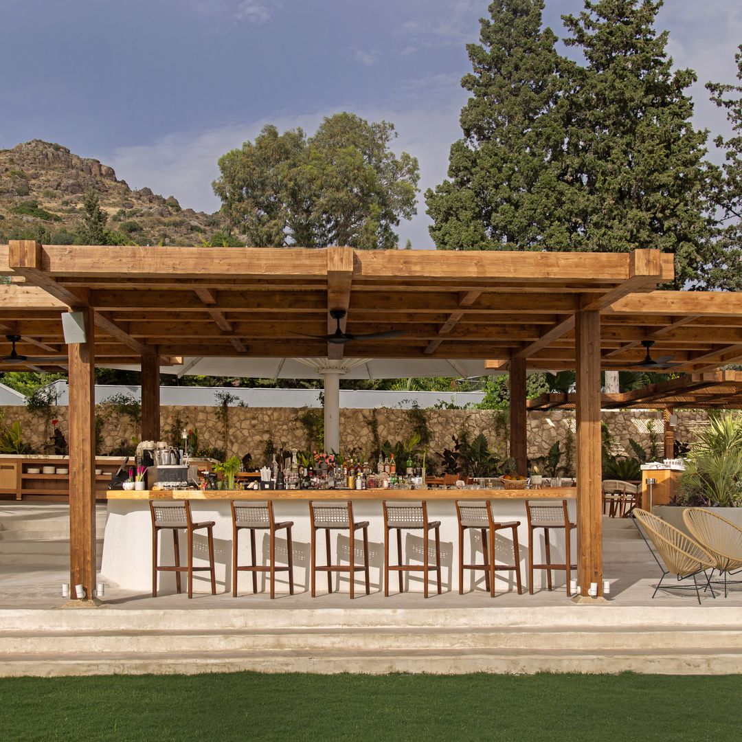 Open-air bar at Avantgarde Refined Bodrum with wooden pergola, seating and landscaped gardens.