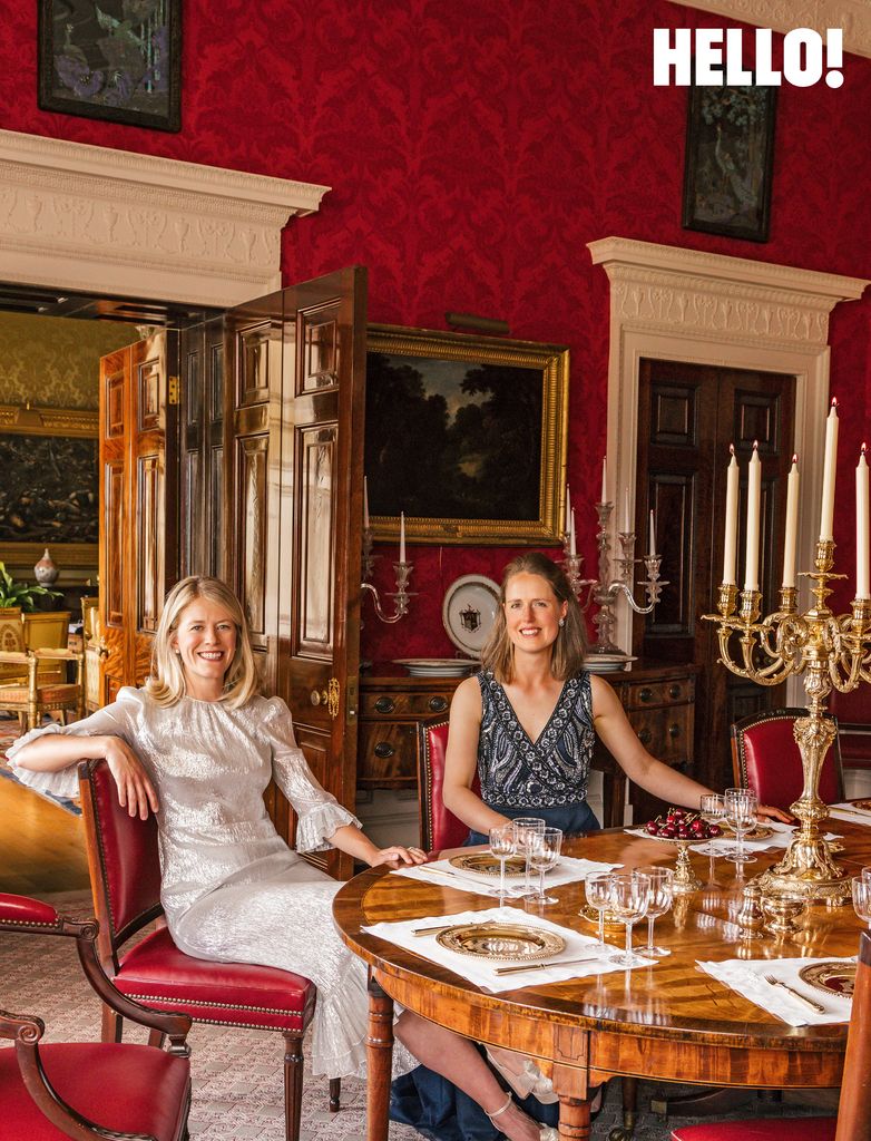 Georgie and Annabel seated in the red-walled dining room at Buscot Park