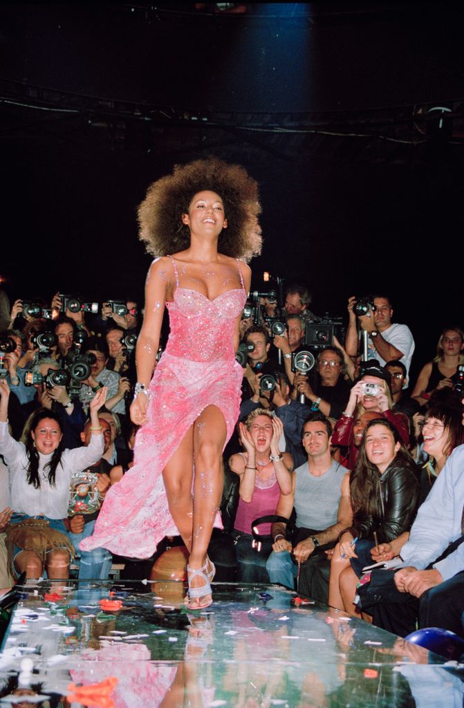 Mel B on the catwalk with Mel C cheering in the background