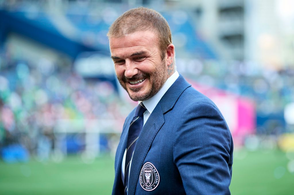David Beckham smiling with short hair on the football pitch
