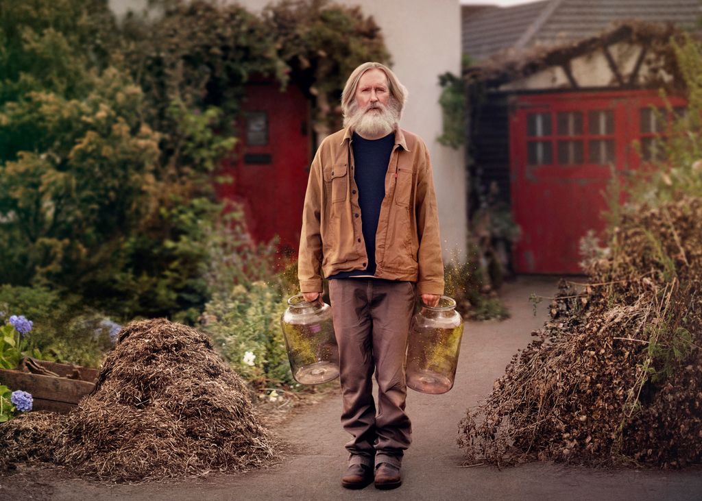man holding water jugs in garden