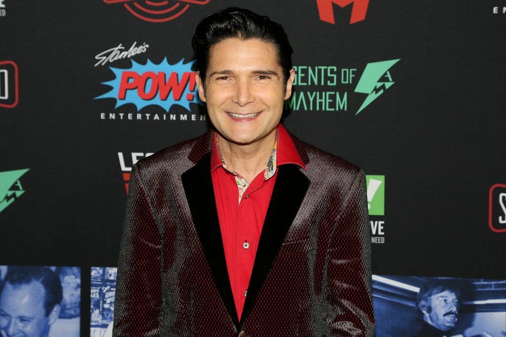Corey Feldman in a red shirt and sparkly jacket at Excelsior! celebrating the life of Stan Lee.