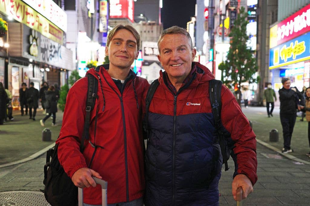 Two men in red rain coats standing in street