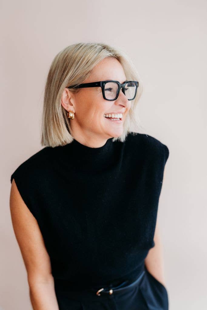 Woman in black top and glasses smiling