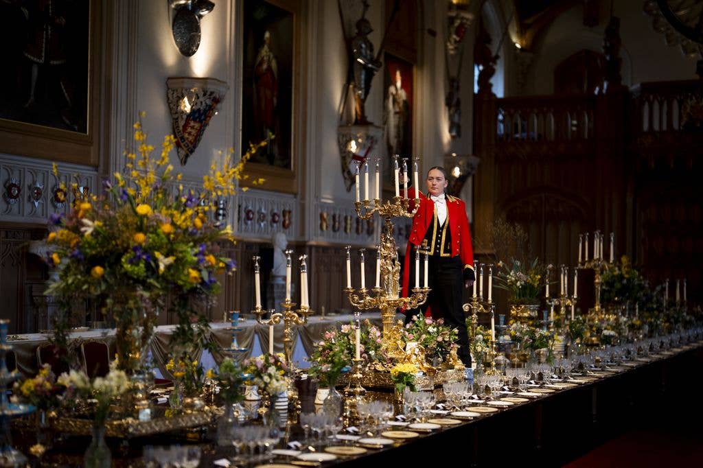 A man in a red uniform lighting candles
