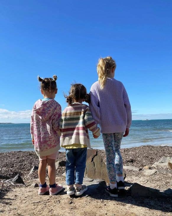 Three young girls looking out to sea
