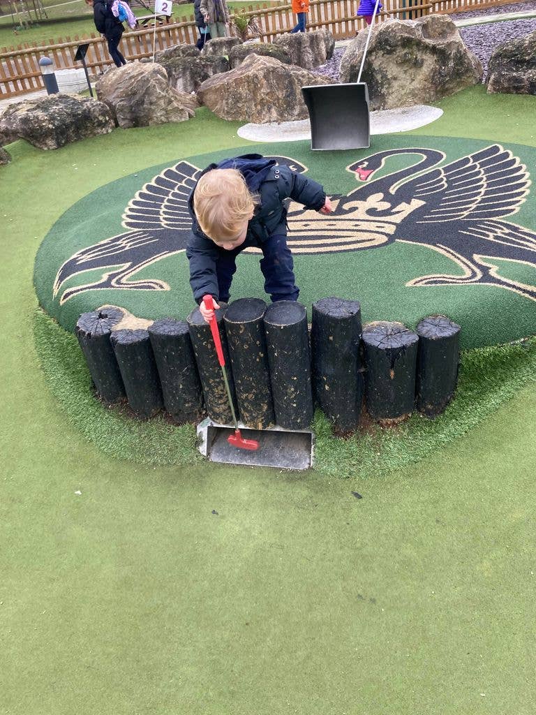 Little boy with blond hair on a crazy golf course