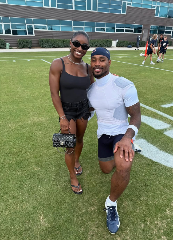 Photo shared by Simone Biles on Instagram visiting Jonathan Owens at football training in which he is kneeling down to her height