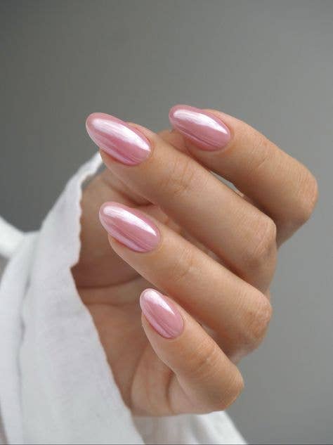 Luminous chrome pastel pink manicure with iridescent glazed finish on long almond nails