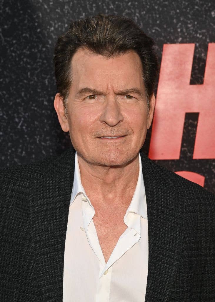 Charlie Sheen in a white shirt and black suit jacket.