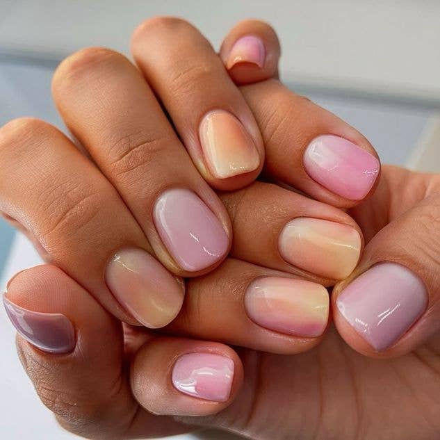 Soft blend aura nails featuring a gradient of sunset pastel shades including apricot and soft rose