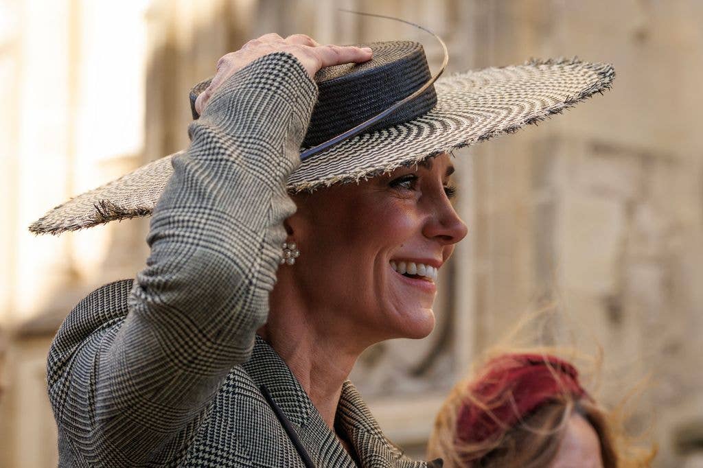 Catherine, Princess of Wales holds on to her hat 