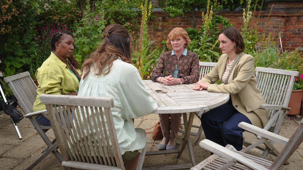 A group of women sitting on garden bench