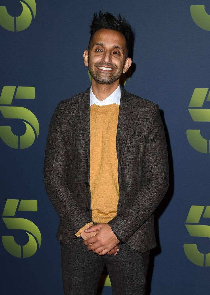 Dr. Amir Khan smiling in a yellow jumper
