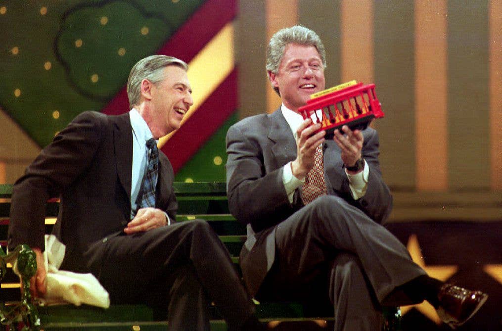 Bill Clinton (R) holds a trolley car given to him by Fred Rogers (L) during the Presidential Inaugural Celebration for Children 19 January 1993 at the Kennedy Center.