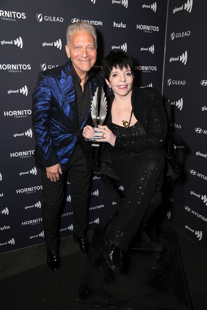 photo of liza minnelli holding award next to michael feinstein
