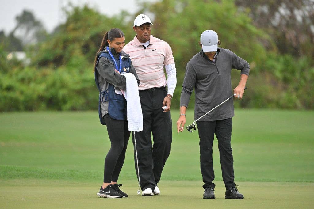 Tiger Woods talks with his son and daughter, Charlie Woods and Sam Woods, on the third green during the first round of the PNC Championship at Ritz-Carlton Golf Club on December 16, 2023 in Orlando, Florida.