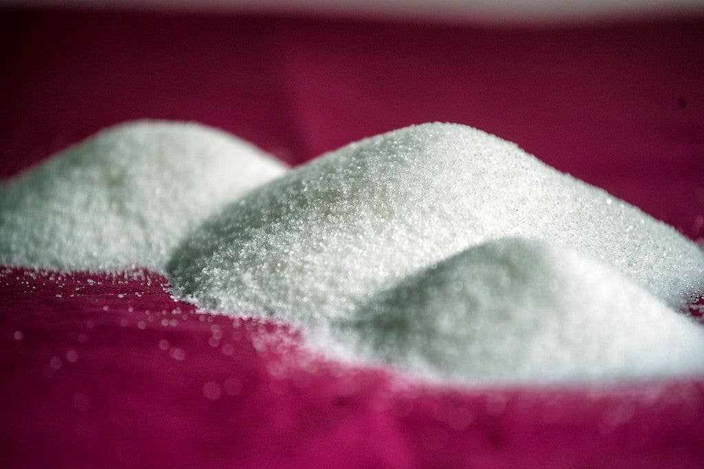 Three piles of sugar on a background of dark red.