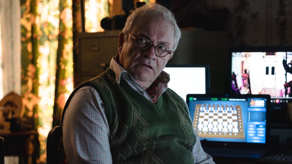 close-up of man in glasses sitting at desk