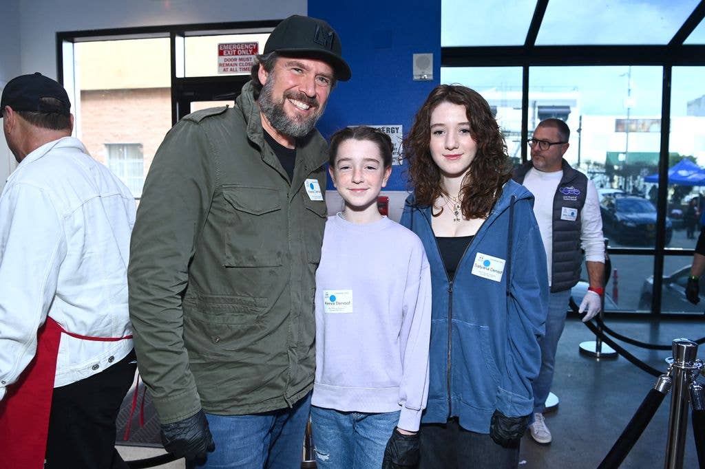 Alexis Denisof, Keeva Jane Denisof and Satyana Marie Denisof stand in practical wear, posing for the camera at Los Angeles Mission.