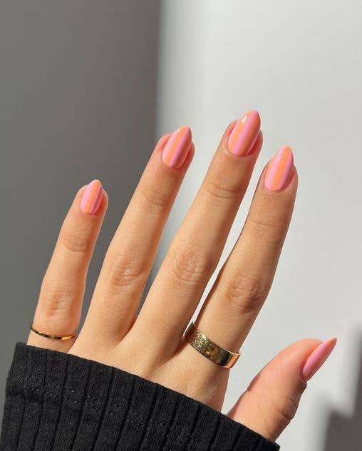 Modern striped nail art using thick vertical bands of pastel pink and vibrant spring orange
