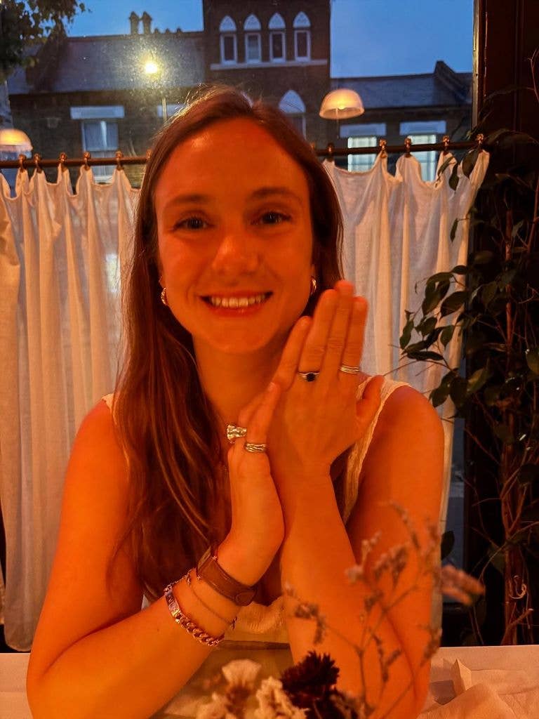 Woman holding up hand in restaurant at night