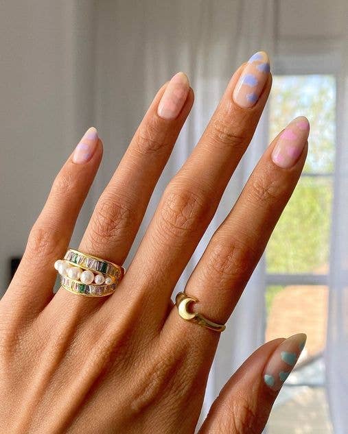 Sweet cloud nail art with white 3D-effect clouds over various pastel base colors for a whimsical spring look