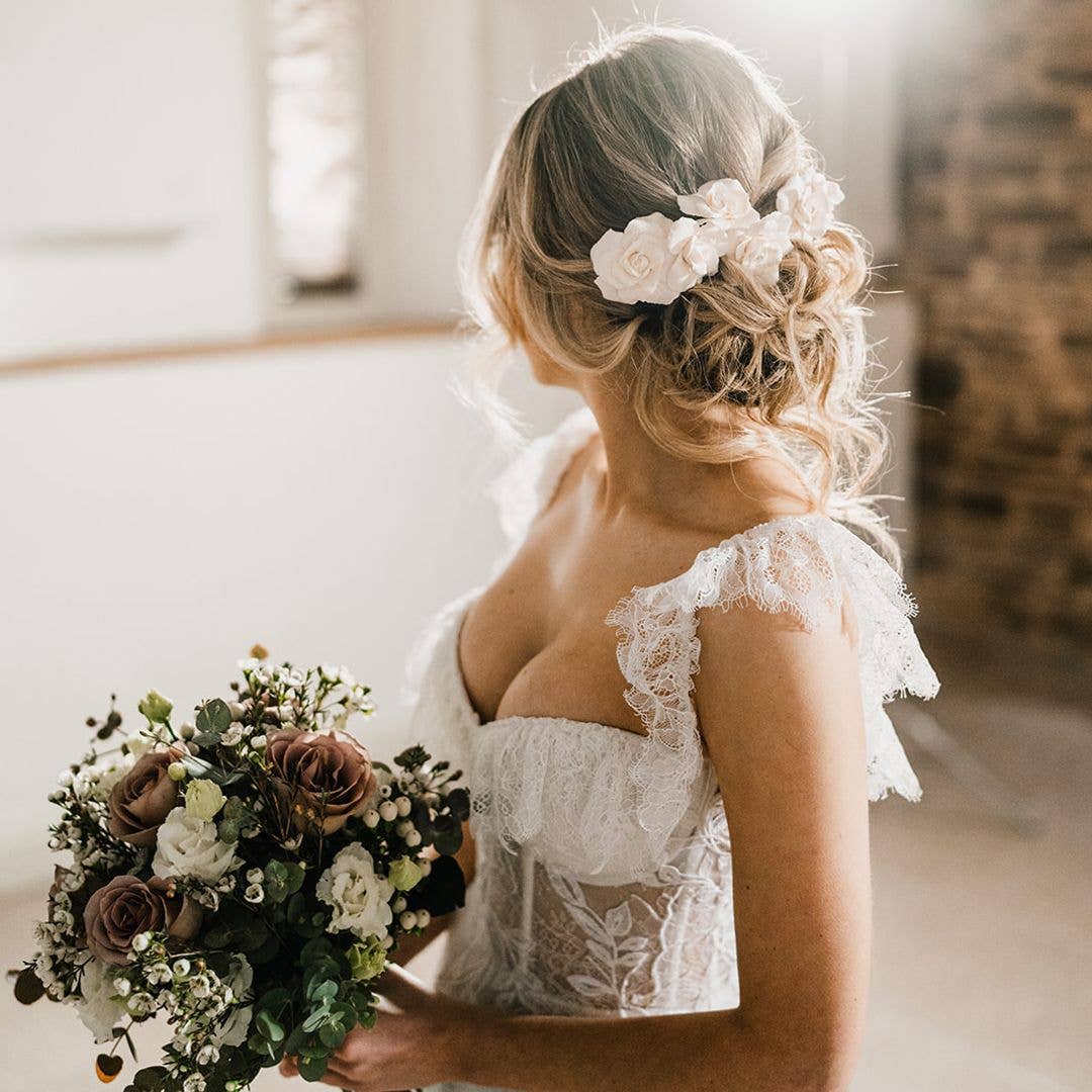 Woman in a wedding dress with her hair in a bun adorned with flowers