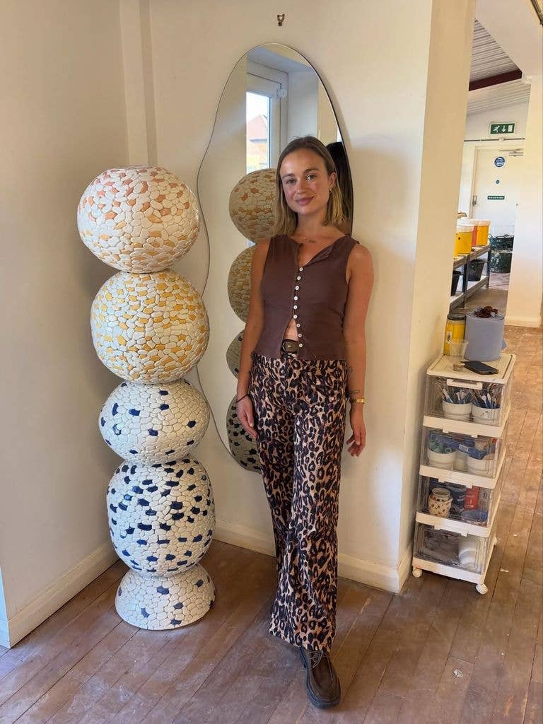 A photo of Lady Amelia Widsor wearing leopard print trousers and a brown vest