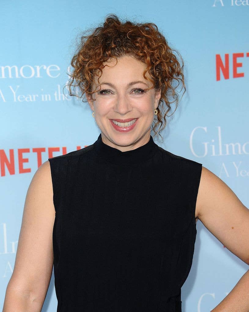 Alex Kingston smiling in a black dress