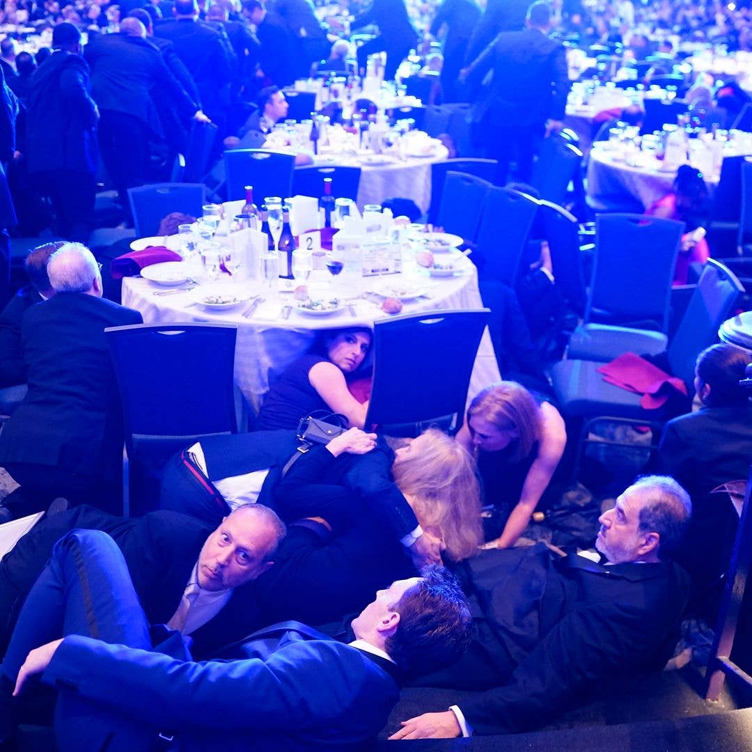 Attendees hide under tables after an  incident at the annual White House Correspondents Association Dinner