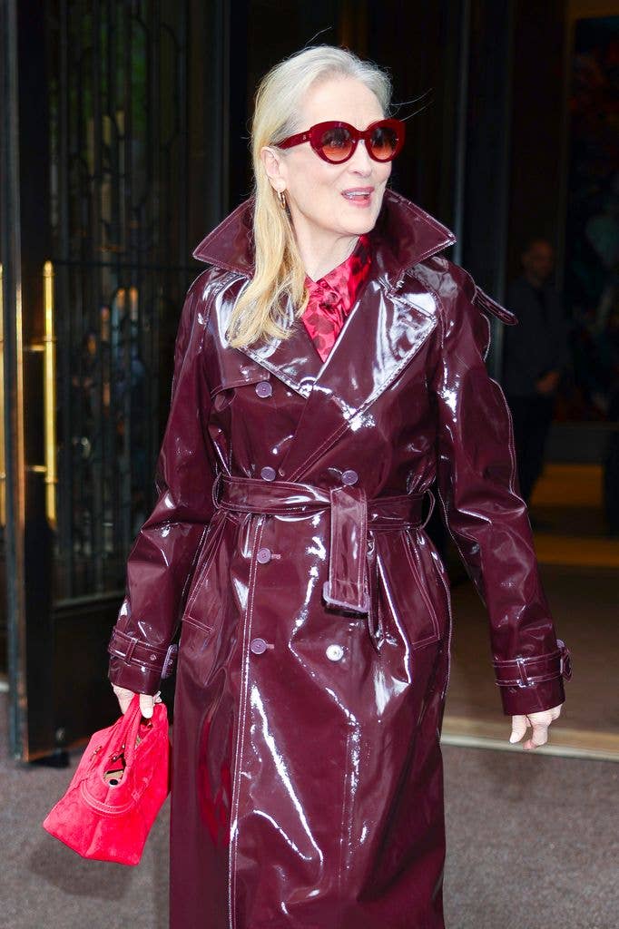 Meryl turned heads in a striking burgundy patent trench coat 